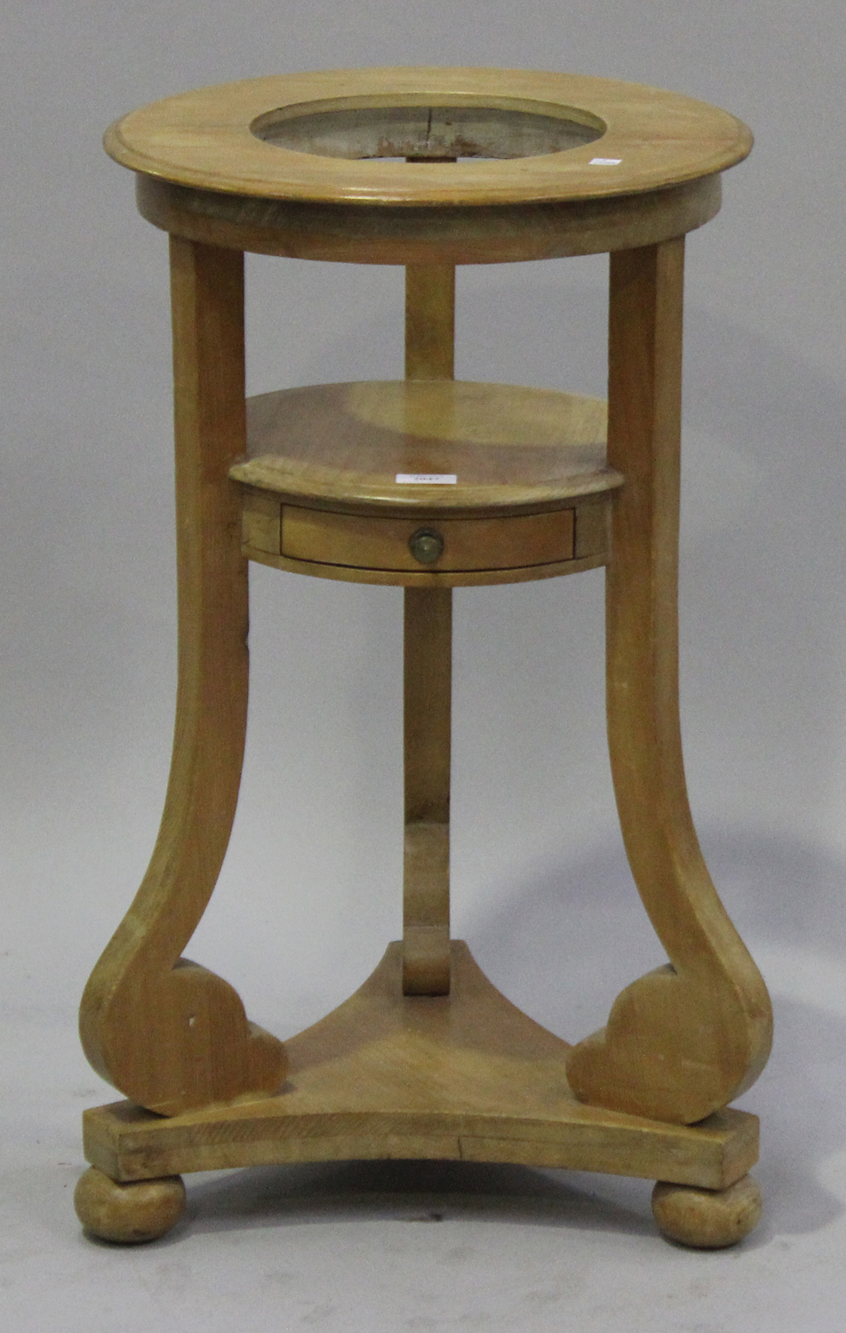 A 20th century Continental pine washstand, the ring top raised on scrolling tripod supports,