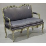 An 18th century French Rococo limed showframe salon settee, upholstered in blue striped damask,