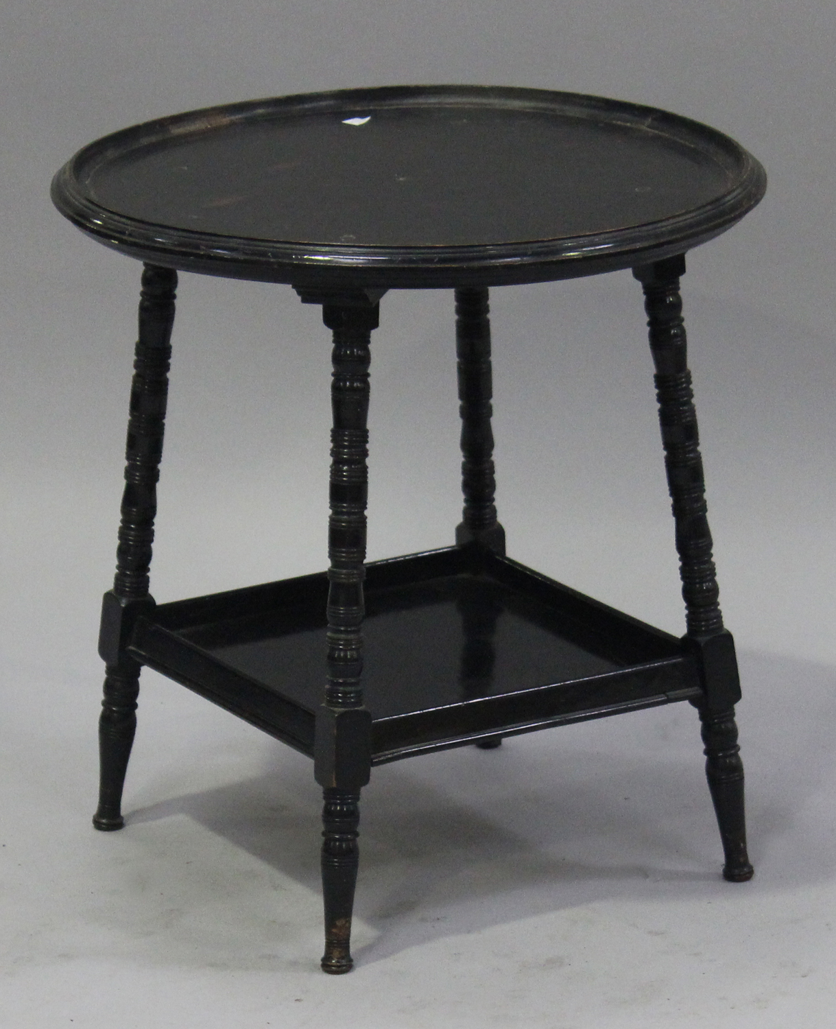 A late Victorian ebonized circular occasional table, in the manner of E.W. Godwin, raised on ring