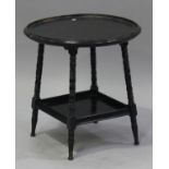 A late Victorian ebonized circular occasional table, in the manner of E.W. Godwin, raised on ring