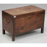 A 20th century Eastern teak trunk, the hinged lid revealing a candle box, on block legs, height