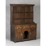 An 18th century oak dresser, the shelf back with a moulded pediment, the base fitted with three