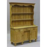 A 20th century pine dresser, the shelf back above three drawers and cupboards, on turned feet,