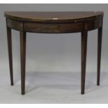 A George III mahogany demi-lune fold-over card table with boxwood stringing and inlaid oval