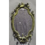 A mid-Victorian gilt composition girandole wall mirror of shaped oval form, the arched top with a