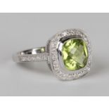 An 18ct white gold, peridot and diamond ring, mounted with a rose cut peridot within an open