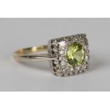 An 18ct gold, peridot and diamond square cluster ring, mounted with a circular cut peridot within