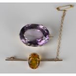 A gold and amethyst oval single stone brooch, detailed '10ct', width 2.8cm, a 9ct gold and yellow