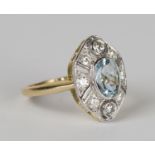 An 18ct gold, aquamarine and diamond ring, collet set with an oval cut aquamarine within an open