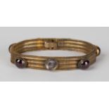 A Victorian gold and carbuncle garnet bracelet of mesh link form, spaced with six carbuncle garnets,