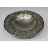 An Egyptian silver footed bowl, the outswept rim cast with foliate panelled decoration, raised on