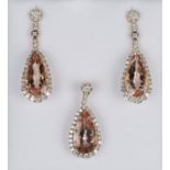 A rose gold, morganite and diamond drop shaped pendant, claw set with a pear shaped morganite within