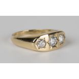 An 18ct gold and diamond ring, star gypsy set with three circular cut diamonds, ring size approx