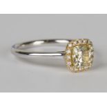 An 18ct white gold, yellow diamond and diamond cluster ring, claw set with a cushion shaped yellow