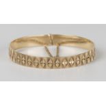 A 9ct gold circular sprung bangle with panel and diamond cut decoration, London 1977, fitted with