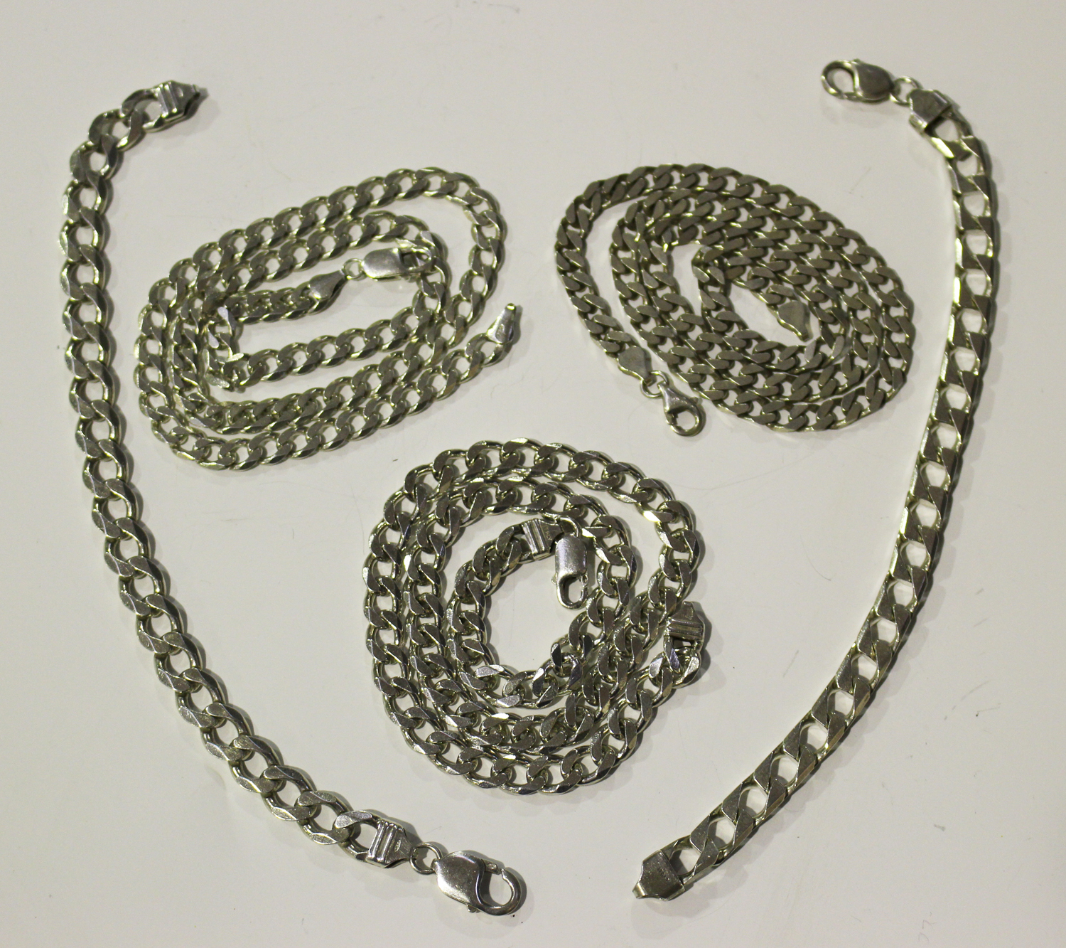 Three silver faceted curblink neckchains, each with a sprung hook shaped clasp, lengths 50.5cm, 49cm