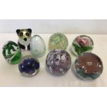 A collection of coloured glass paperweights.