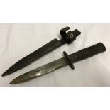 A German WWII fighting knife with wooden handle, metal sheath and leather strap.