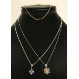 2 silver necklaces, one with a filigree silver flower, the other with pale lilac stone.