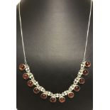 A silver necklace with 12 amber drops.
