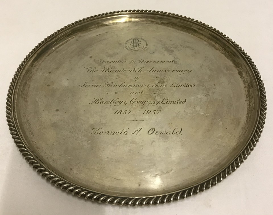 A hallmarked silver salver with engraving.