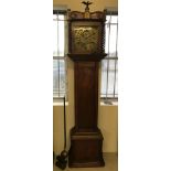 An antique long case clock with brass dial and sundial and mahogany case.