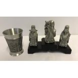 3 pewter Chinese figures on a wooden stand.