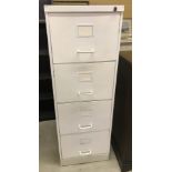 A vintage metal lockable 4 drawer filing cabinet, painted white.