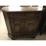 A dark oak 2-door hall cupboard with central drawer.