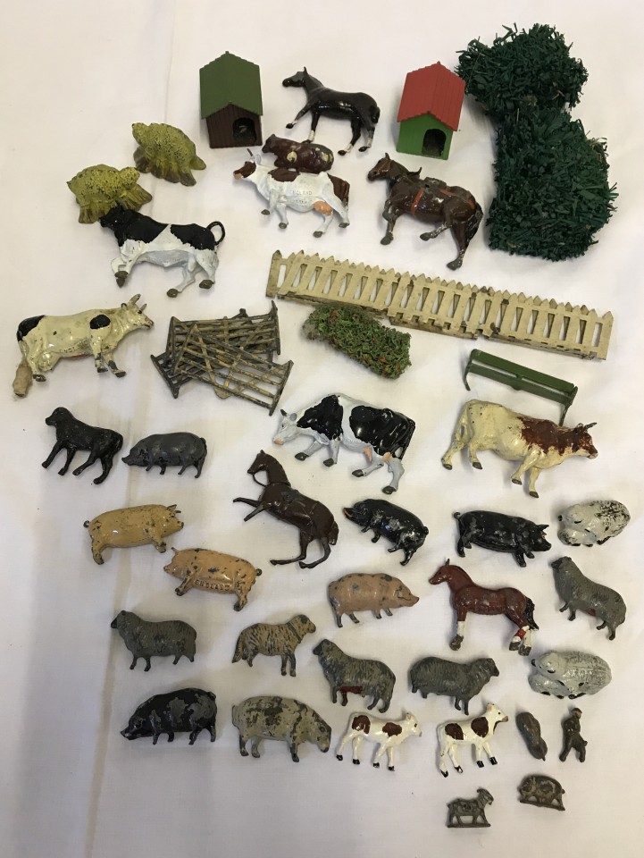 A box of vintage lead farm animals and accessories.