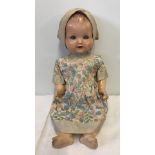 An Armand Marseille composite baby doll with vintage silk dress and bonnet.