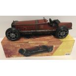 A boxed tin plate model of a red Bugatti racing car.