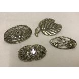4 silver and white metal brooches.