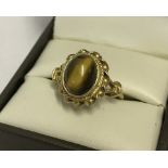 A 9ct gold ladies dress ring set with central oval Tiger's eye stone.