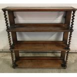 An Antique dark wood wall hanging shelf with barley twist columns.