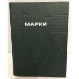 A Russian Mapkn green stamp album containg Russian, Mongolian and Cuban stamps.