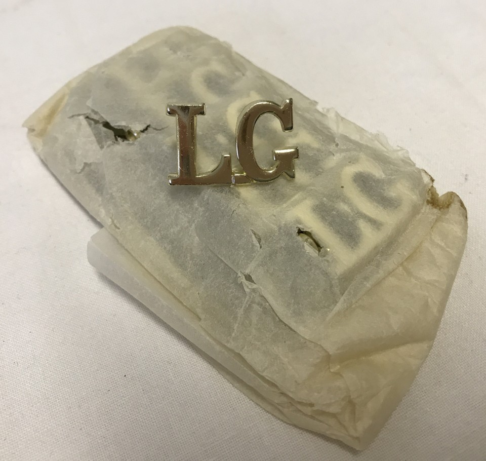 A quantity of 11 L.G. metal letter badges.