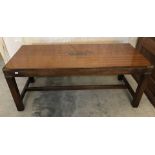 A vintage wooden rectangular coffee table with brass banding and central plaque.