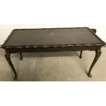 A reproduction coffee table with cabriole legs and piecrust edge to top.