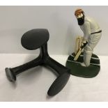 A modern cast iron doorstop in the shape of a cricketer.