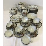 A vintage oriental ceramic eggshell teaset with handpainted mountain scene decoration.