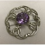 A scottish Silver brooch set with a late central amethyst.