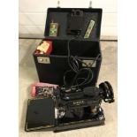 A vintage cased electric Singer sewing machine complete with original tools, oil can and foot pedal.