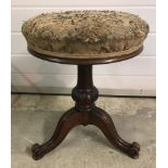 A Victorian mahogany pedestal based swivel top piano stool with tripod legs.