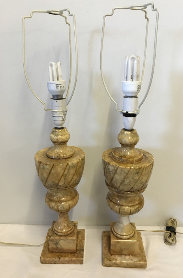 A pair of vintage marble lamp bases together with a pair of cream and gold lampshades.