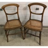 A pair of vintage wooden frame balloon back cane seated chairs.