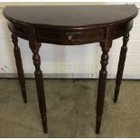 A modern reproduction half circle hall table with turned legs and central drawer to front.