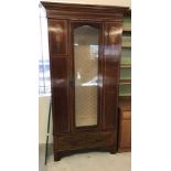 A vintage mahogany single door wardrobe, been converted to a glass cabinet.