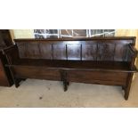 A large vintage stained pine church pew.