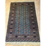 A vintage teal rug with navy, gold and cream coloured decoration.